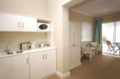 a kitchen with a sink and a microwave at 61 on Camps Bay in Cape Town