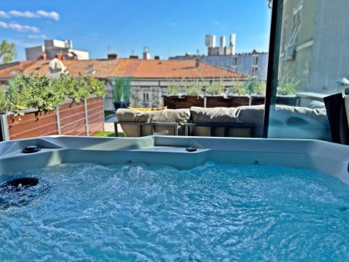 a hot tub on a balcony with a view of a city at Villa Olivetta heritage residence in Crikvenica