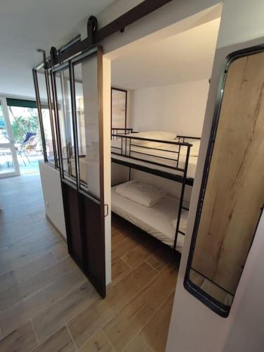 Cette chambre comprend 2 lits superposés et une porte. dans l'établissement Studio neuf au cœur de la presqu'île, à Lège-Cap-Ferret