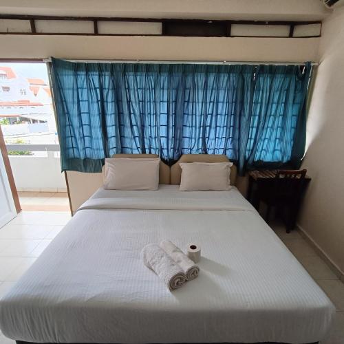 a bedroom with a bed with two towels on it at Kota Lodge Guest House in Melaka