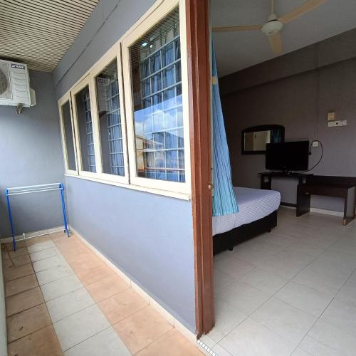 a small room with a bed and a window at Kota Lodge Guest House in Melaka