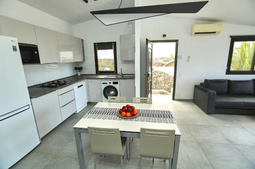 una cocina con una mesa con un bol de fruta. en Villa Sotavento Modern new apartment in Park Natural Ocean view Adults Only, en Playa de Jandía