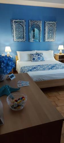 a blue bedroom with a bed and a table at Casa Del Sole B&B in Tropea