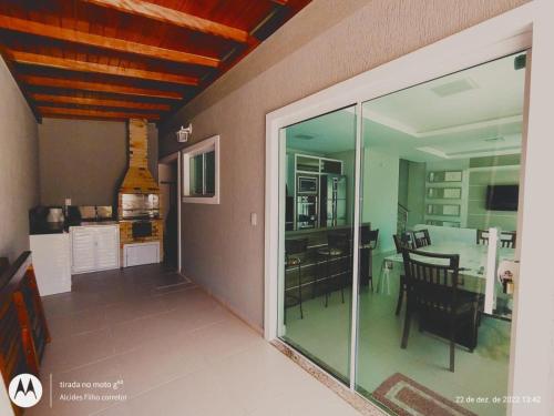 sala de estar con puertas de cristal y comedor en Casa alto Padrão para temporada - cod 62, en Bombinhas