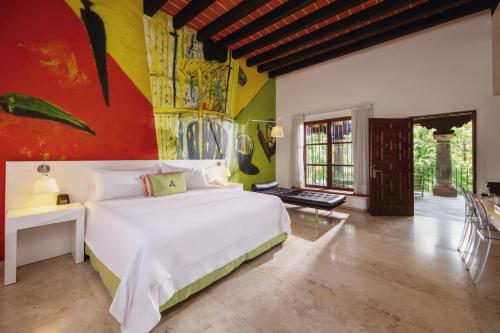 una camera con un letto bianco e una parete colorata di Anticavilla Hotel Restaurante & Spa a Cuernavaca
