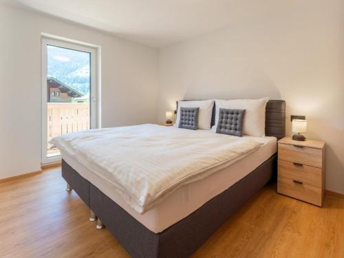 a bedroom with a large bed and a large window at Villa Felding Top 4 in Bad Hofgastein