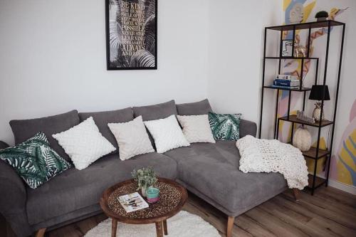 a living room with a gray couch and a table at Cozy Dreams: Deluxe 2-Zimmer-Apartment -Küche in Nürnberg