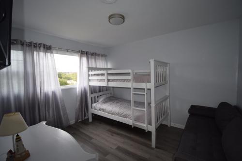 a white bunk bed in a room with a window at Oceanfront vacation property - West in Emerald Isle
