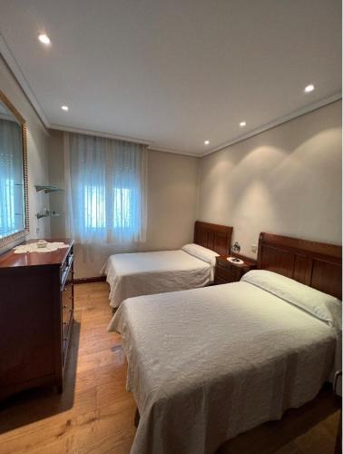 a hotel room with two beds and a desk at Apartamento Céntrico Pamplona San Fermin in Pamplona