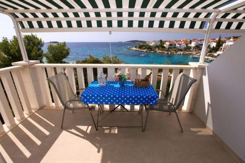 uma mesa numa varanda com vista para o oceano em Apartments by the sea Rogoznica - 4805 em Rogoznica