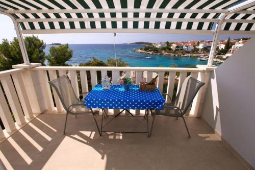 a table on a balcony with a view of the ocean at Apartments by the sea Rogoznica - 4805 in Rogoznica
