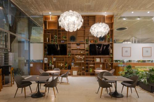 ein Esszimmer mit Tischen und Stühlen und Kronleuchtern in der Unterkunft Anticavilla Hotel Restaurante & Spa in Cuernavaca