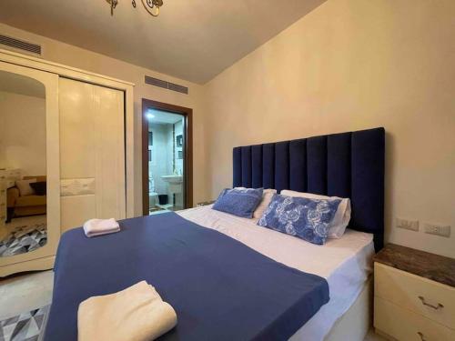 Un dormitorio con una gran cama azul con almohadas azules en Entire duplex for a lovely vacation in Nyoum New Cairo en El Cairo