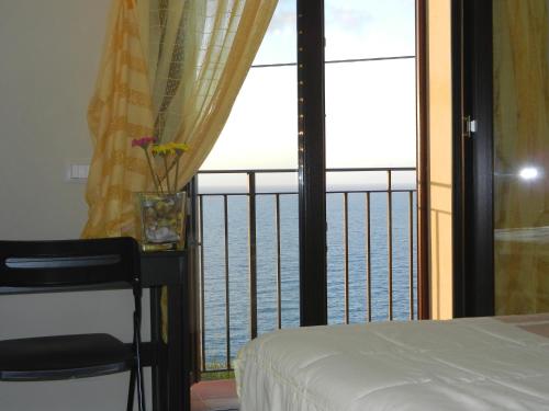 a bedroom with a view of the ocean from a balcony at FraMavi in Cefalù