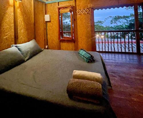 1 dormitorio con 1 cama grande y balcón en Shambhala Quarto Ecológico Beira Mar entre Paraty e Ubatuba en Ubatuba