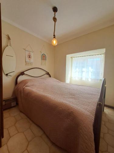 a bedroom with a bed and a window at Casa Terreiro Da Lapa in Quintela