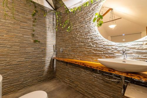 a bathroom with a sink and a brick wall at Casa Sobreiros in Sever do Vouga