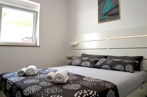 - une chambre avec un lit et des serviettes dans l'établissement Apartments with a parking space Preko, Ugljan - 21491, à Preko