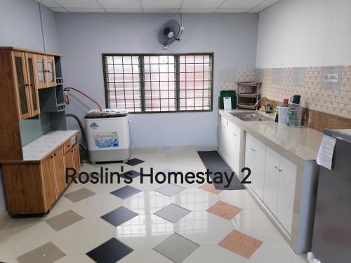 eine Küche mit weißen Schränken und Fliesenboden in der Unterkunft Roslin's Homestay 2 in Kota Bharu