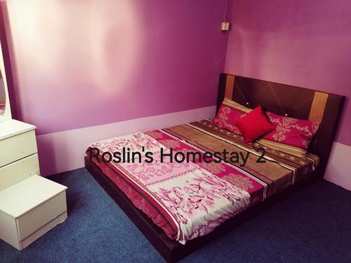 Schlafzimmer mit einem Bett mit rosa Wänden in der Unterkunft Roslin's Homestay 2 in Kota Bharu