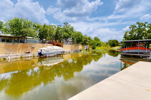 a boat is docked on a river at Woodland Hills Retreat in Marble Falls