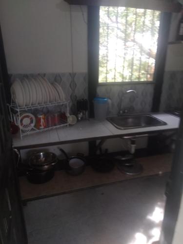 uma cozinha com um lavatório e um balcão com panelas e frigideiras em El Edén em El Ocaso
