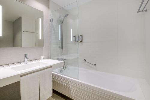 a white bathroom with a shower and a sink at AC Hotel San Cugat by Marriott in Sant Cugat del Vallès