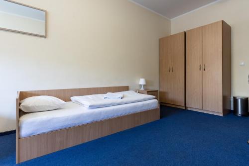 a bedroom with a large bed and wooden cabinets at Gdańska Szkoła Szermierki in Gdańsk