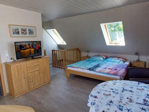 a bedroom with a bed and a television in it at Cosy Apartment Ostsee in Zierow with Terrace in Zierow