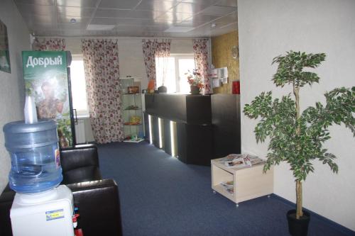 a waiting room with two potted trees in a room at Hotel POSHALE in Bryansk