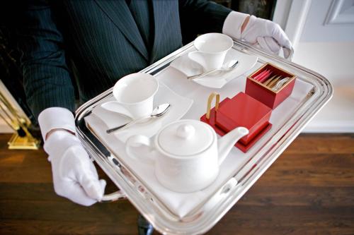a person holding a tray filled with cups and dishes at The St. Regis Osaka in Osaka