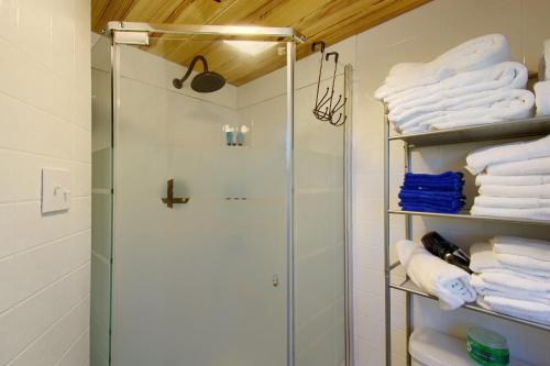 um chuveiro na casa de banho com toalhas brancas em The Americana - Parker Creek Bend Cabins em Murfreesboro