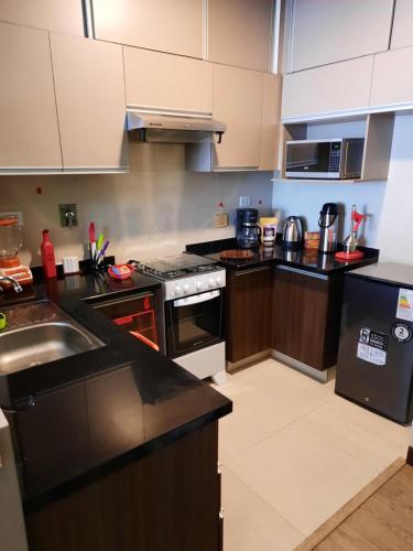 a kitchen with black counters and white cabinets at Experiencia Recoleta in Cochabamba