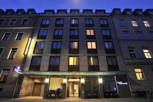 a building with lights on in front of it at Hotel Concorde in Munich