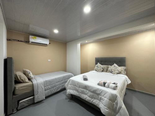 a bedroom with two beds and a bed at Hostal Casa Jardin Cartagena in Cartagena de Indias