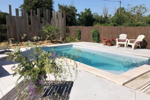 - une piscine avec 2 chaises et une clôture dans l'établissement Heritage cottage near the forest, à Frontenay-sur-Dive