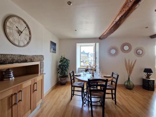une salle à manger avec une table et une horloge au mur dans l'établissement Duplex in Plougasnou near Stunning Beaches, à Plougasnou