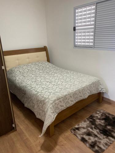 - une chambre avec un lit dans une pièce dotée d'une fenêtre dans l'établissement Apartamento do Renan, à Espirito Santo Do Pinhal