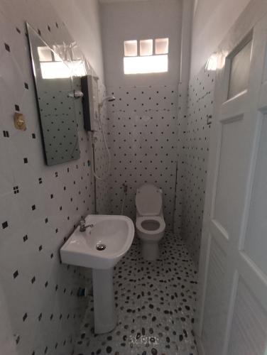a white bathroom with a sink and a toilet at Orchid 101 in Kampot