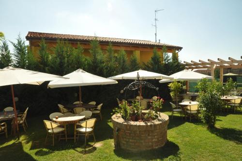 a patio with tables and chairs and umbrellas at Osteria e Locanda Del Viaggiatore in Russi