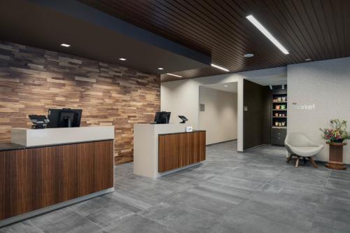 ナナイモにあるCourtyard by Marriott Nanaimoの石壁のオフィスロビー(フロントデスク付)