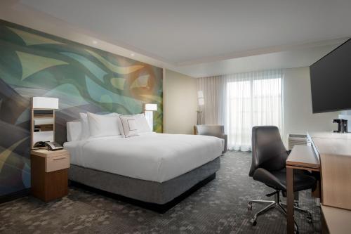 a hotel room with a bed and a desk at Courtyard by Marriott Nanaimo in Nanaimo