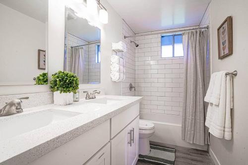 a white bathroom with a sink and a toilet at Spacious 4BR Home - 5 min to SeaTac Airport in SeaTac