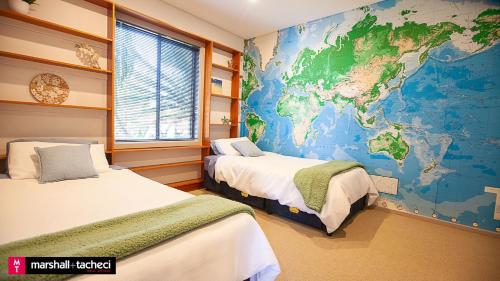 ein Zimmer mit zwei Betten und einer Karte an der Wand in der Unterkunft Bermagui jewel holiday house 5 Bedroom Uninterrupted views central location Bermagui Linen & Wifi Provided in Bermagui