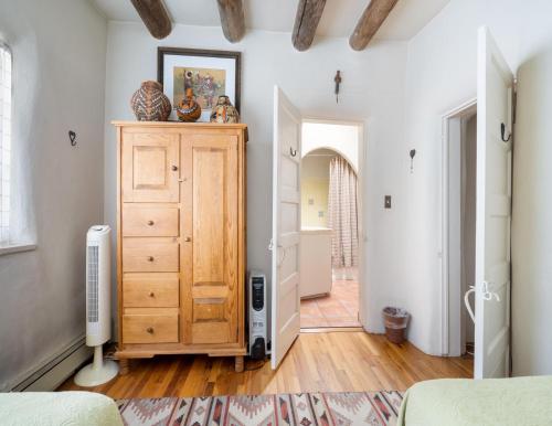 a bedroom with a wooden dresser and a hallway at Harmony House, 3 Bedrooms, 2 wood fireplaces, 3 patios in Santa Fe