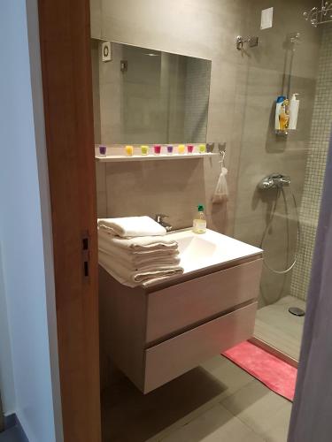 a bathroom with a sink and a shower with a mirror at Apparemment Rockisland in Mohammedia