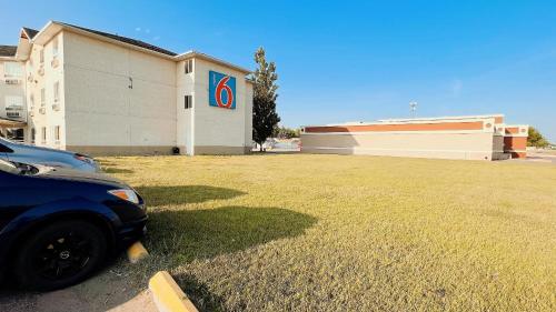 a car parked in a parking lot next to a building at Motel 6-Regina, SK in Regina