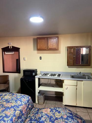 a kitchen with a stove and a sink in a room at Economy Inn Odessa in Odessa