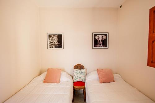 a room with two beds and a chair in it at REGINA HOME in San Salvador de Jujuy