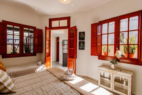 1 dormitorio con 2 camas y ventanas rojas en REGINA HOME en San Salvador de Jujuy